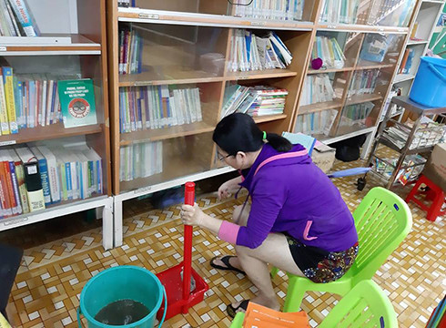 Nhân viên thư viện Trường Bông Sao đang tát nước ra khỏi phòng (ảnh: P.L) Nhân viên thư viện Trường Bông Sao đang tát nước ra khỏi phòng (ảnh: P.L)