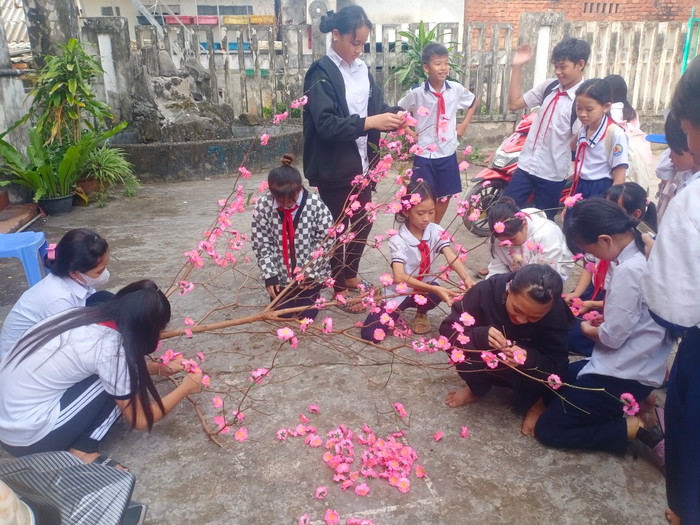 Các bạn học sinh cùng nhau làm cây đào đón tết. (Ảnh: NTCC) Các bạn học sinh cùng nhau làm cây đào đón tết. (Ảnh: NTCC)
