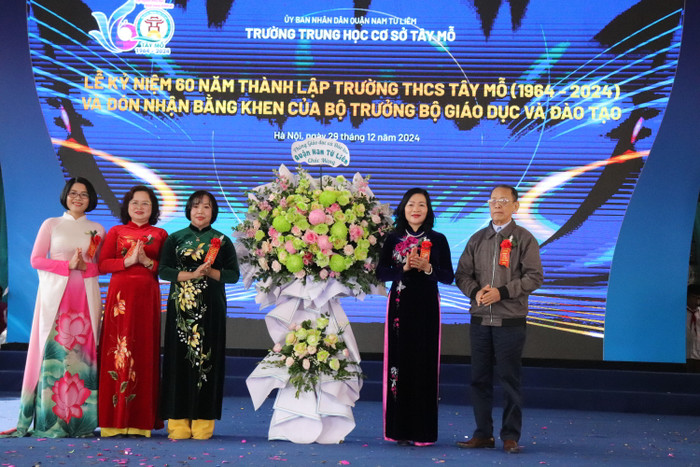 Đại diện Phòng Giáo dục và Đào tạo quận Nam Từ Liêm tặng hoa chúc mừng nhà trường. (Ảnh: Nhật Lệ) GDVN-TAY-MO (14).JPG