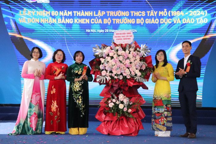 Đại diện cha mẹ học sinh tặng hoa chúc mừng nhà trường. (Ảnh: Nhật Lệ) GDVN-TAY-MO (17).JPG