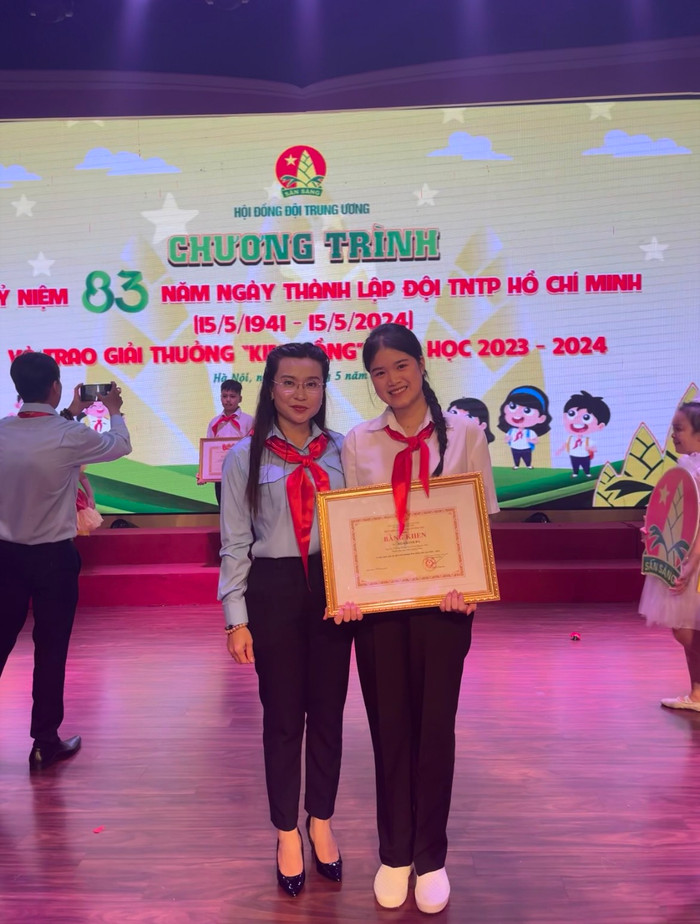 Bạn Hồ Khánh Hà chụp ảnh lưu niệm cùng Chủ tịch Hội đồng Đội Trung ương Nguyễn Phạm Duy Trang trong lễ trao giải. (Ảnh: NVCC) ho-khanh-ha-2.jpg