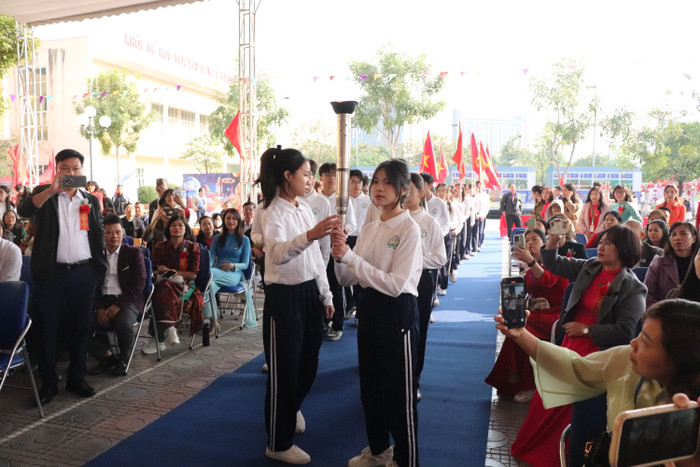 Các thế hệ học sinh nhà trường truyền tay nhau ngọn đuốc thắp sáng truyền thống hiếu học của trường. (Ảnh: Nhật Lệ) GDVN-TAY-MO (45).JPG