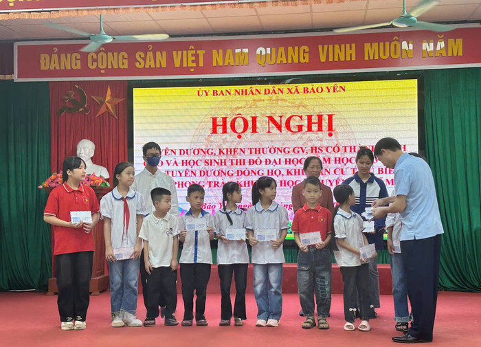 Huyền Linh (thứ 2 từ phải sang) được địa phương tuyên dương là một trong những học sinh đạt thành tích học tập nổi bật. Ảnh: Diệp Anh GDVN_nu-sinh.jpg
