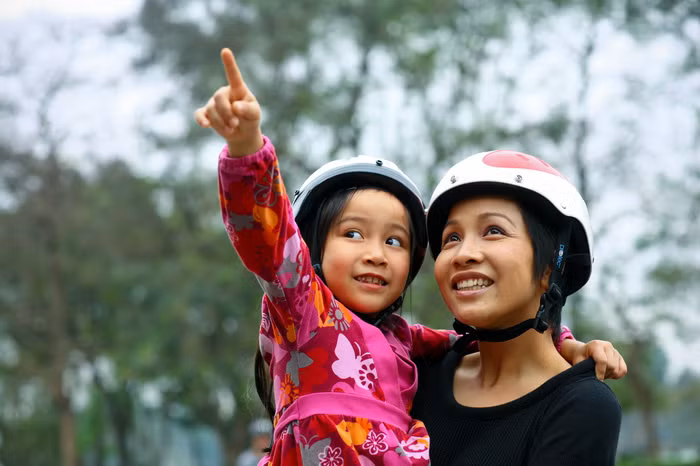 Con với mẹ đội mũ bảo hiểm xong thì đi tập xe trên cái dốc cao đằng kia nhé.