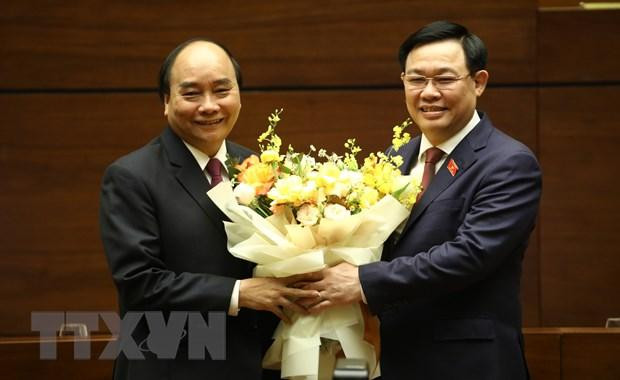 Chủ tịch Quốc hội Vương Đình Huệ chúc mừng Thủ tướng Nguyễn Xuân Phúc hoàn thành xuất sắc nhiệm vụ. (Ảnh: Văn Điệp/TTXVN)