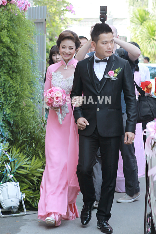 Chiếc áo dài cưới màu hồng được cách điệu bằng khoảng trái tim trắng trông khá rườm rà và hơi cầu kỳ 'quá mức'