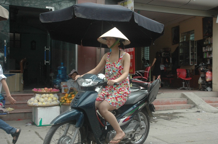 "Nón" bảo hiểm, áo hai dây và quần...ngắn. Một cách chống nóng và nắng khá hiệu quả tuy nhiên nguy hiểm đang rình rập bởi tham gia giao thông nhưng không đội mũ bảo hiểm.