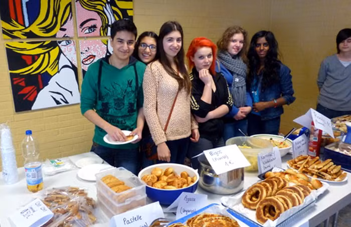 Nhóm học sinh bán bánh trước cổng một xí nghiệp lớn để thu tiền quyên góp