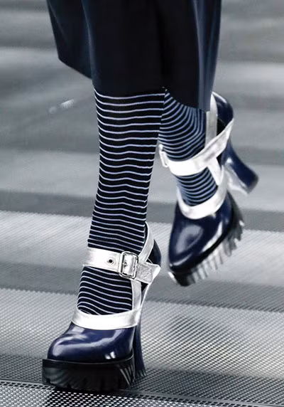 Với bộ sưu tập Miu Miu, vẻ nữ tính của sandal cao gót quai ngang được bổ sung vẻ "hầm hố" với phần đế cao su dày mang những đường rãnh đặc trưng của bốt quân đội.