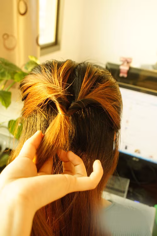 Chia giữa phần tóc và luồn đuôi tóc vào trong lận ngược lại.