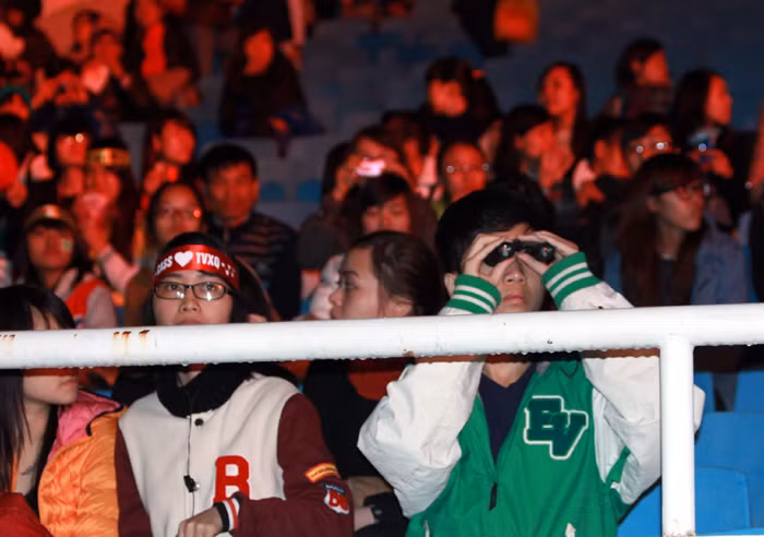 Do khoảng cách ngồi quá xa sân khấu, một fan nam đã mang theo ống nhòm để thấy rõ thần tượng hơn.