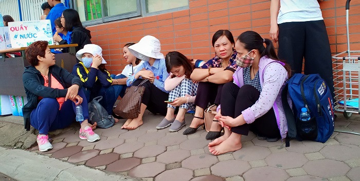 Phụ huynh ngồi đợi con thi xong môn đầu tiên - môn Ngữ Văn (Ảnh: Vũ Ninh)