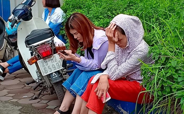 Người mẹ mệt mỏi thiêm thiếp ngủ trong khi đợi con thi xong môn Toán (Ảnh: Vũ Ninh)