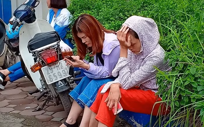 Người mẹ mệt mỏi thiêm thiếp ngủ trong khi đợi con thi xong môn Toán (Ảnh: Vũ Ninh)