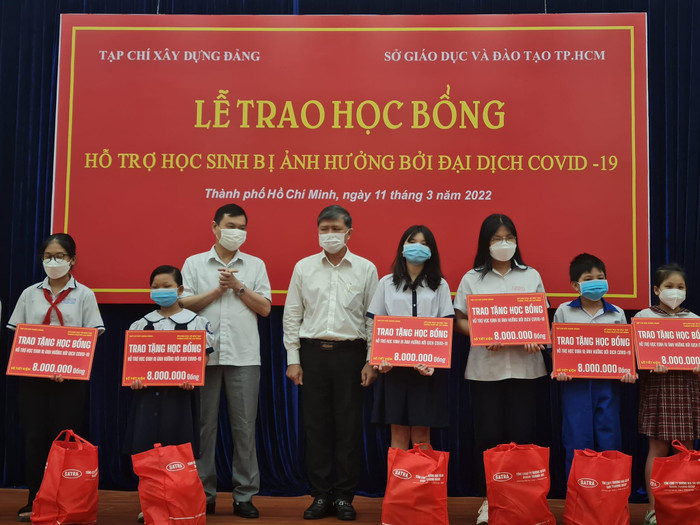 Ông Nguyễn Văn Hiếu (đứng thứ 4, trái sang) trao tặng học bổng cho các em học sinh (ảnh: P.L)