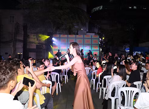 Ca sĩ Đông Nhi đang trình bày ca khúc "Nụ cười Việt Nam" tại sân khấu ngoài trời (ảnh: NHG)