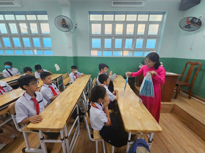 Giáo viên chủ nhiệm lớp 6/1 phát quà kỷ niệm của nhà trường dành cho học sinh lớp 6 (ảnh: V.D) gdvn_hslop6VTTb.jpg