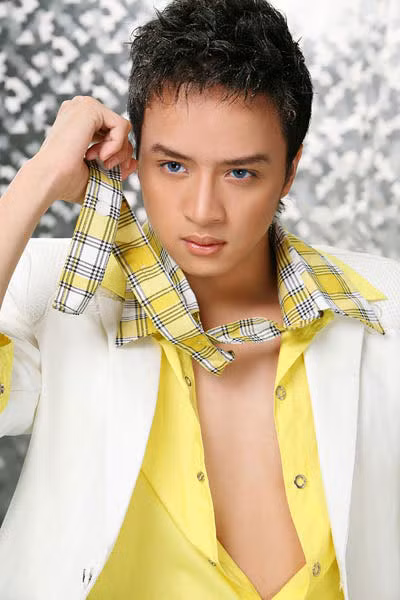 Với chiếc áo sơ mi phanh ngực màu vàng nổi bật này, Cao Thái Sơn mix nó với vest trắng tinh khôi và thanh lịch. Điểm nhấn chính là chiếc cravat kẻ xuyệt tông và màu mắt xanh ma mị.