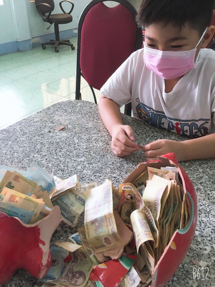 Em Lê Đức Anh "làm thịt" con heo đất của mình trước sự chứng kiến của bố mẹ và ông Phạm Văn Bình (Ảnh: CTV) Em Lê Đức Anh "làm thịt" con heo đất của mình trước sự chứng kiến của bố mẹ và ông Phạm Văn Bình (Ảnh: CTV)