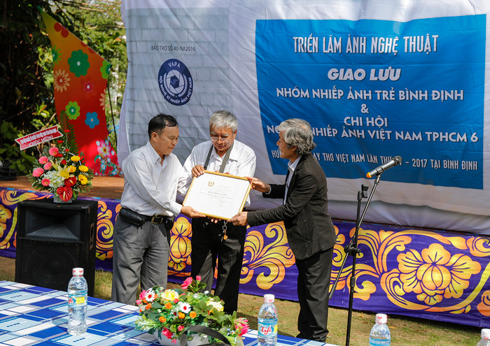 Nghệ sĩ nhiếp ảnh Đào Tiến Đạt – Uỷ viên Ban chấp hành Hội Nghệ sĩ nhiếp ảnh Việt Nam trao giấy bảo trợ của Hội Nhiếp ảnh Việt Nam.