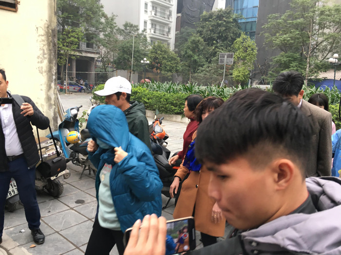 Bà Quy trùm kín mít trong vòng vây của phóng viên. Ảnh: Vũ Phương.