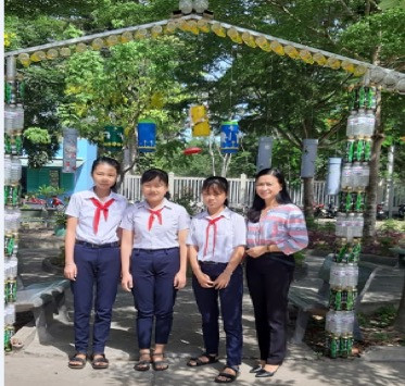 Ly cùng cô giáo Nga với các bạn bên cổng rác thải nhựa của chi đội 9A. Ảnh: Sơn Quang Huyến