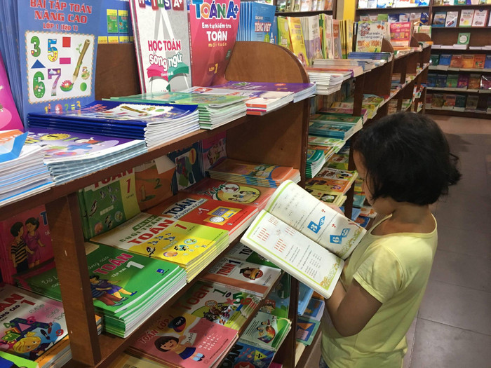 Nhiều phụ huynh vì lo ngại con bị trù dập, để ý đành chấp nhận mua sách giáo khoa tại trường thay vì mua tại cửa hàng, đại lý được chiết khấu theo giá bìa. Ảnh: Vũ Phương. Nhiều phụ huynh vì lo ngại con bị trù dập, để ý đành chấp nhận mua sách giáo khoa tại trường thay vì mua tại cửa hàng, đại lý được chiết khấu theo giá bìa. Ảnh: Vũ Phương.