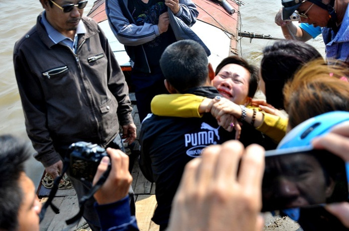 "Nhà ngoại" cảm (áo vàng) đang biểu lộ hành vi nhập vong, khóc nức nở bên người thân của chị Huyền