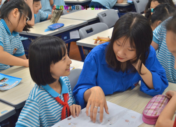 Sinh viên nhiệt tình giải thích cho các em học sinh những kiến thức cơ bản (Ảnh: Khánh Vy)