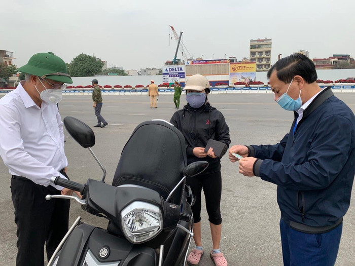 Chị N (một tiểu thương) chia sẻ: "Tôi đang đi chợ mua đồ ăn thì bị dừng lại kiểm tra, vì không mang theo giấy tờ nên đành gọi người nhà mang tới và cố gắng giải thích để không bị xử phạt”. Ảnh: Đình Hùng