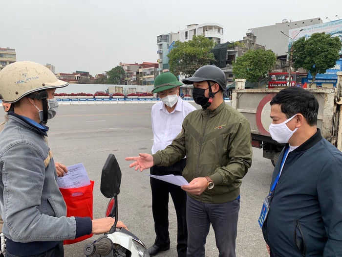 Một tiểu thương được yêu cầu xuất trình giấy tờ kinh doanh. Ảnh: Đình Hùng