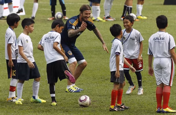 Beckham rất vui vẻ khi hướng dẫn cho các em nhỏ chơi bóng