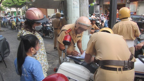 Một trường hợp phụ huynh vi phạm không đội mũ cho trẻ em trong ngày đầu tiên bị xử phạt (Ảnh: T.Q) Một trường hợp phụ huynh vi phạm không đội mũ cho trẻ em trong ngày đầu tiên bị xử phạt (Ảnh: T.Q)