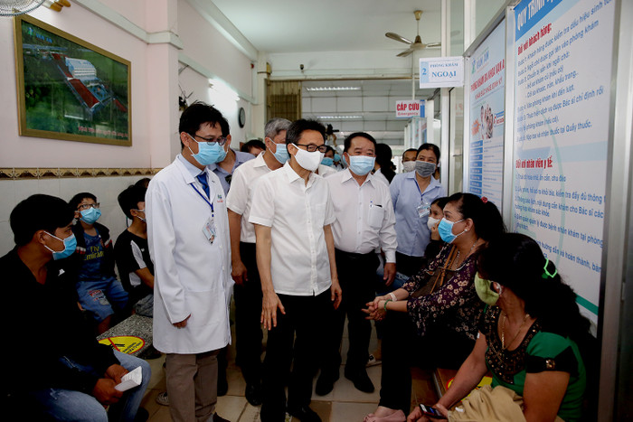 Phó Thủ tướng Vũ Đức Đam nói chuyện với người dân đến khám bệnh tại Phòng khám đa khoa Vạn An, Thành phố Tân An, tỉnh Long An. Ảnh: VGP/Đình Nam
