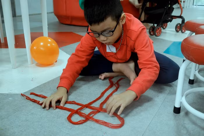 Một bạn nhỏ miệt mài với những nút thắt của nghệ thuật đan tết Macrame