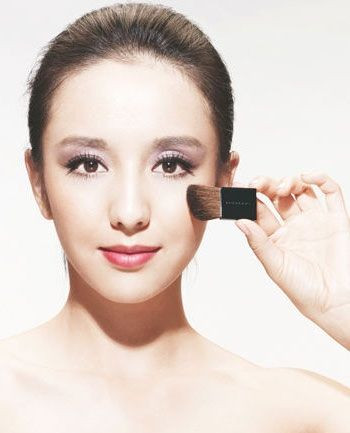 Phủ một lớp phấn nhũ mỏng lên toàn bộ khuôn mặt để thêm nổi bật. Sau đó, tô son màu nâu đỏ, ít bóng.