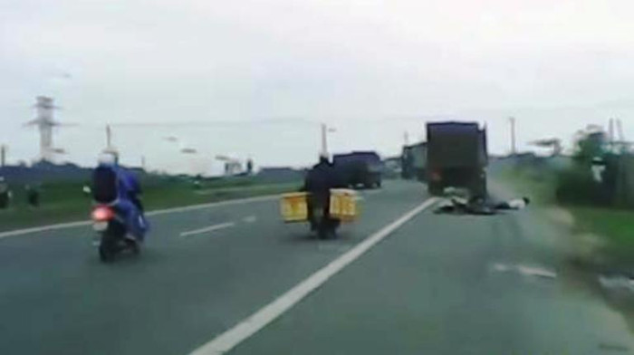 Hai người ngồi trên xe máy bị xe tải cán qua Hai người ngồi trên xe máy bị xe tải cán qua