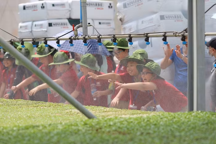 Các em học sinh hào hứng với hệ thống tưới tự động tại nông trường VinEco