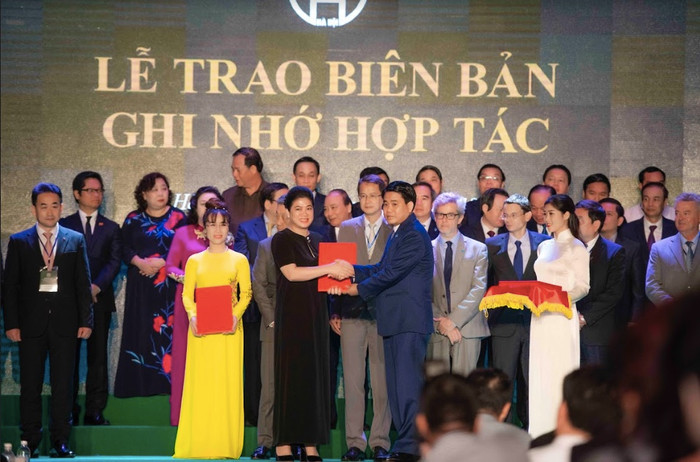 Bà Đỗ Thị Kim Liên - Chủ tịch Công ty Cổ phần Nước AquaOne đại diện Liên danh: Công ty Cổ phần Nước AquaOne và Tập đoàn Aone Deutschland AG lên sân khấu trao, nhận biên bản ghi nhớ do ông Nguyễn Đức Chung - Chủ tịch Uỷ ban nhân dân Thành phố Hà Nội trao. Bà Đỗ Thị Kim Liên - Chủ tịch Công ty Cổ phần Nước AquaOne đại diện Liên danh: Công ty Cổ phần Nước AquaOne và Tập đoàn Aone Deutschland AG lên sân khấu trao, nhận biên bản ghi nhớ do ông Nguyễn Đức Chung - Chủ tịch Uỷ ban nhân dân Thành phố Hà Nội trao.