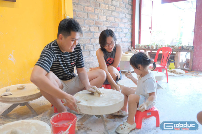 Gia đình chị Nguyễn Thị Khánh trải nghiệm làm gốm tại một cửa hàng xã Bát Tràng. Ảnh: Hồng Mai gdvn-z6857833969582-df56dcfd5151097d273f3e50fc77785d.jpg