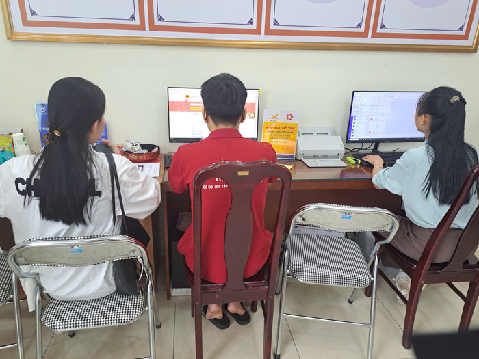 Em Phạm Doãn Quang Minh (áo đỏ), sinh viên Trường Cao đẳng Công nghệ cao Hà Nội, đang tích cực hỗ trợ người dân nhập dữ liệu và sử dụng các dịch vụ số. Ảnh: KH. 94858a91177f9f21c66e.jpg