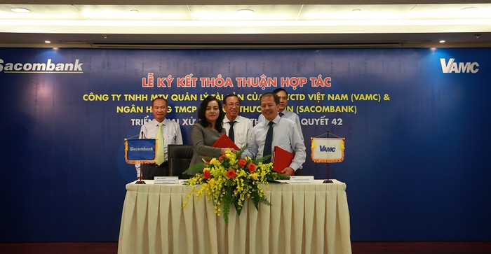 Bà Nguyễn Đức Thạch Diễm – Tổng giám đốc Sacombank và ông Đoàn Văn Thắng – Tổng giám đốc VAMC ký kết thỏa thuận hợp tác với sự chứng kiến của ông Nguyễn Hoàng Minh – Phó giám đốc Ngân hàng Nhà nước Chi nhánh Thành phố Hồ Chí Minh, ông Dương Công Minh – Chủ tịch Hội đồng Quản trị Sacombank và ông Nguyễn Tiến Đông – Chủ tịch Hội đồng Thành viên VAMC. Bà Nguyễn Đức Thạch Diễm – Tổng giám đốc Sacombank và ông Đoàn Văn Thắng – Tổng giám đốc VAMC ký kết thỏa thuận hợp tác với sự chứng kiến của ông Nguyễn Hoàng Minh – Phó giám đốc Ngân hàng Nhà nước Chi nhánh Thành phố Hồ Chí Minh, ông Dương Công Minh – Chủ tịch Hội đồng Quản trị Sacombank và ông Nguyễn Tiến Đông – Chủ tịch Hội đồng Thành viên VAMC.