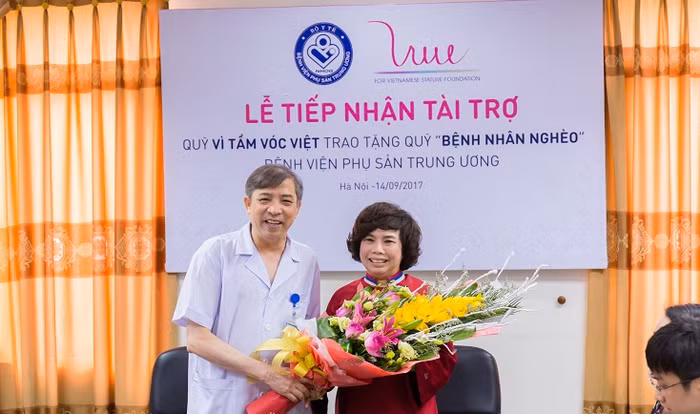 Phó Giáo sư Vũ Bá Quyết - Giám đốc Bệnh viện Phụ sản Trung ương tặng hoa bà Thái Hương - Chỉ tịch Quỹ vì tầm vóc Việt. ảnh: THV.