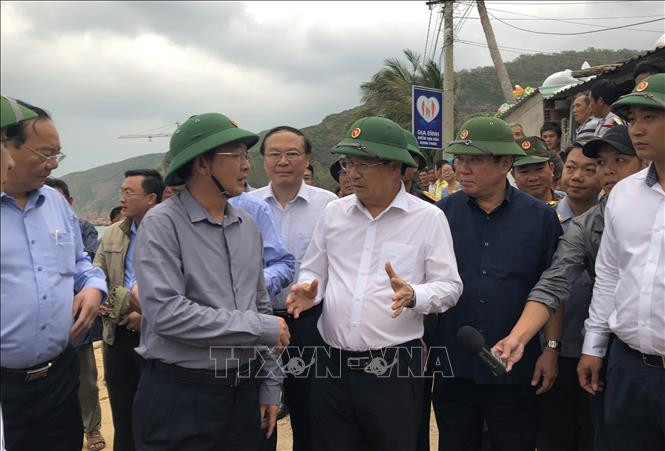 Phó Thủ tướng Trịnh Đình Dũng trao đổi với Chủ tịch Ủy ban nhân dân tỉnh Bình Định về công tác ứng phó với bão số 6 tại xã Nhơn Hải, Thành phố Quy Nhơn. Ảnh: Nguyên Linh/TTXVN