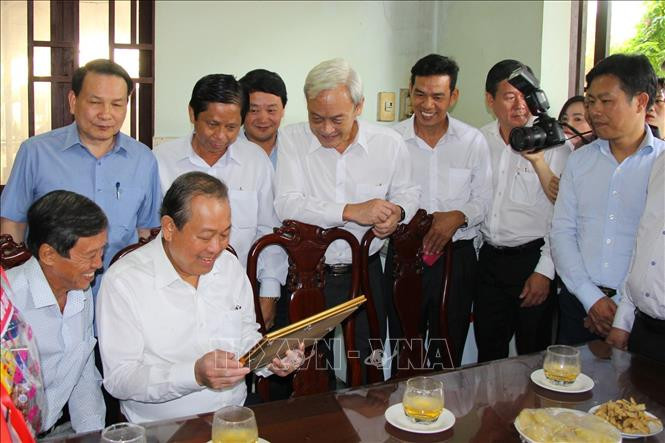 Phó Thủ tướng thường trực Trương Hòa Bình đến thăm, tặng quà các gia đình có công với cách mạng tại ấp Tân Triều. (Ảnh minh họa: TTXVN).