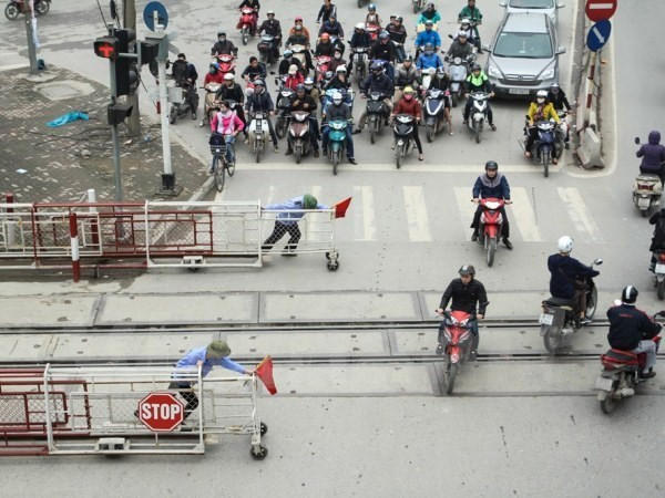 Dù đã có có tín hiệu và nhân viên kéo ba-ri-e chắn tàu nhưng nhiều người vẫn bất chấp lao qua. ảnh: TTXVN. Dù đã có có tín hiệu và nhân viên kéo ba-ri-e chắn tàu nhưng nhiều người vẫn bất chấp lao qua. ảnh: TTXVN.