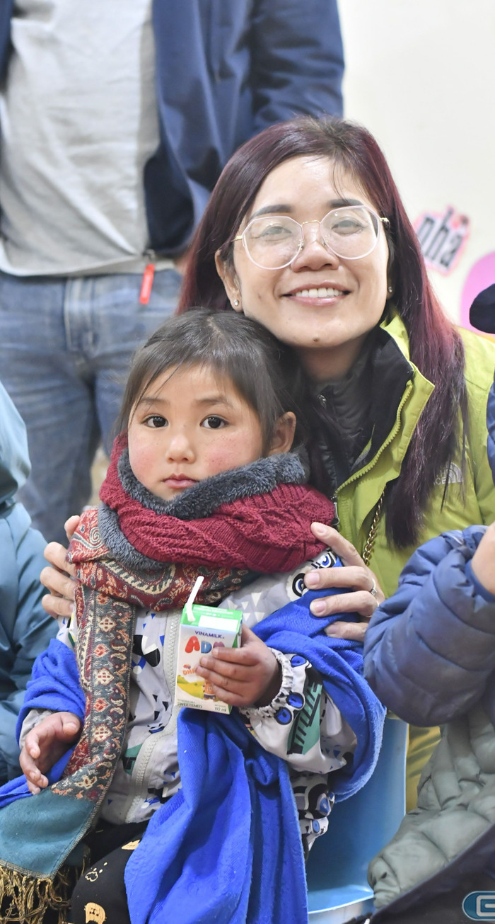 Tiến sĩ Trần Thị Ngọc Diệp - Trưởng Trung tâm Khu vực miền Nam về Giáo dục Phát triển bền vững tặng chiếc khăn mình đang đeo cho em nhỏ đang run vì lạnh. (Ảnh: Ngọc Mai).