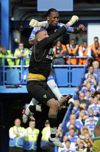 Trong một pha tranh bóng trên không, Didier Drogba đã va chạm với thủ môn John Ruddy của Norwich City. Trong một pha tranh bóng trên không, Didier Drogba đã va chạm với thủ môn John Ruddy của Norwich City.