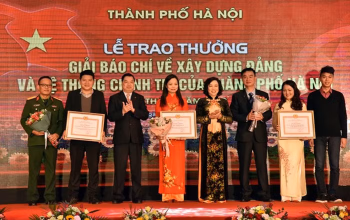 Đồng chí Ngô Thị Thanh Hằng và đồng chí Lê Mạnh Hùng trao giải A cho các tác giả đạt Giải Báo chí về xây dựng Đảng và hệ thống chính trị của Thành phố Hà Nội lần thứ I - năm 2018 (Ảnh: Báo Nhân dân).