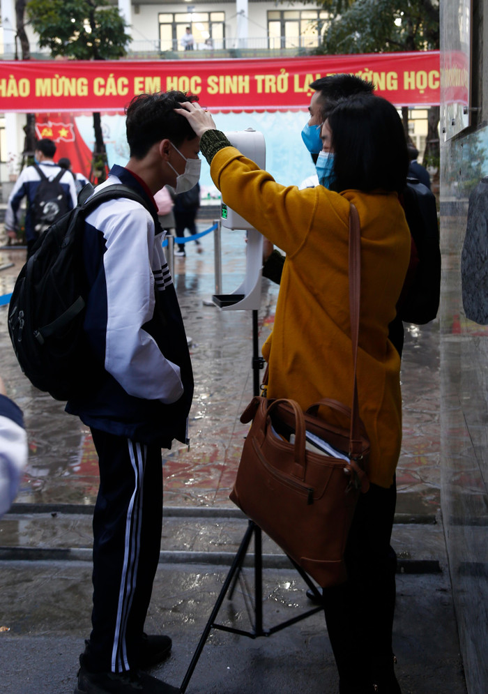Giáo viên của Trường Trung học phổ thông Khương Đình đo thân nhiệt cho học sinh trước khi cho các em vào lớp. Ảnh: Nhật Tân Giáo viên của Trường Trung học phổ thông Khương Đình đo thân nhiệt cho học sinh trước khi cho các em vào lớp. Ảnh: Nhật Tân